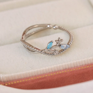Macro shot of adjustable silver ring featuring blue marquise crystals and flower details