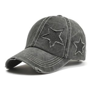 Detail of distressed star patches and contrast stitching on washed cotton baseball cap