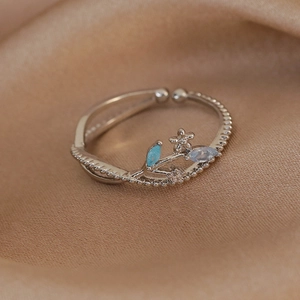 Detailed close-up of a silver adjustable ring featuring floral motifs and colorful zircons