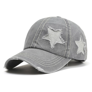 Detail of grey washed baseball cap with silver sequin stars and distressed frayed edges