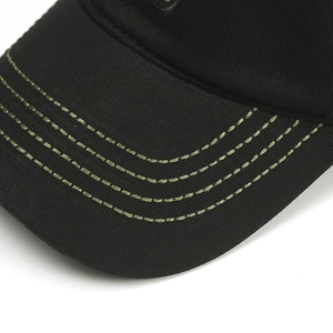 Close-up detail of black cotton twill baseball cap brim with olive green parallel stitching