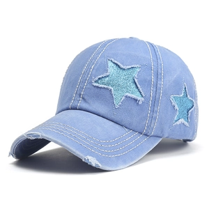 Detail view of washed denim baseball cap with blue sequin stars and distressed vintage edges