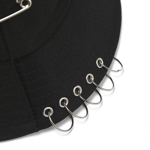 Close-up of black cotton bucket hat featuring silver metal rings and eyelet decorations