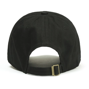 Close-up of adjustable vintage brass buckle on black cotton canvas baseball cap