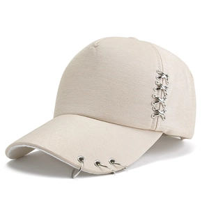 Dettaglio cappello beige con anelli metallici e decorazioni argentate a forma di X incrociata