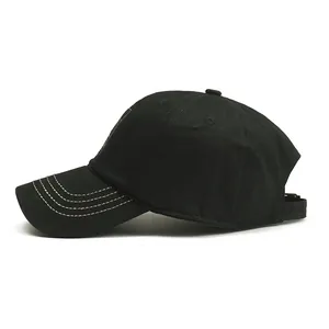 Detail view of the black cotton baseball cap showing contrast stitching and visor craftsmanship