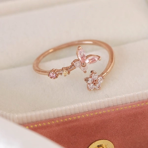 Macro detail of adjustable rose gold ring with pink marquise butterfly and white zircon flower
