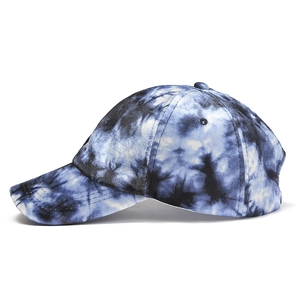Detailed view of tie-dye baseball cap with blue and white patterns and stitched brim