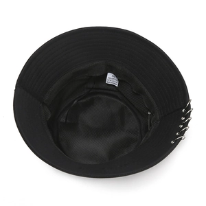 Detail shot of the inner washing label and silver metal rings on a black cotton bucket hat