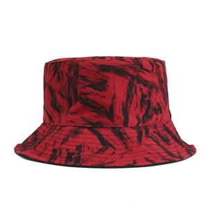 Detailed close-up showing black tie-dye patterns on a bright red cotton bucket hat