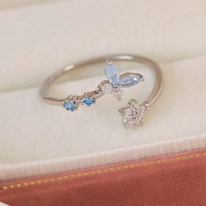 Macro shot of silver adjustable ring featuring a blue zircon butterfly and star detail