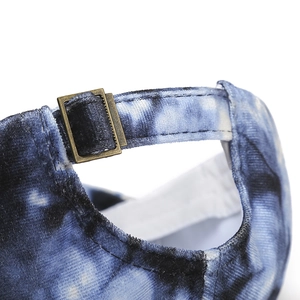 Detail of blue tie-dye velvet baseball cap with adjustable bronze metal buckle back