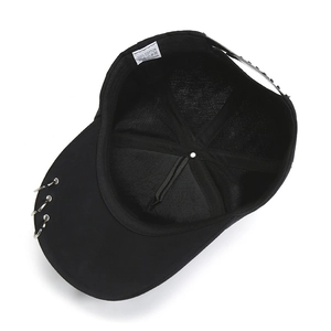 Dettaglio dell'etichetta 100% cotone e della chiusura regolabile del cappellino nero