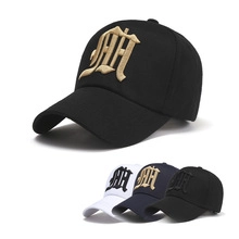Detail of embroidered gothic letters on structured cotton baseball caps in three colors