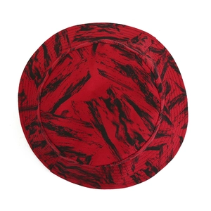 Flat lay of red bucket hat with black abstract brushstrokes on premium cotton fabric