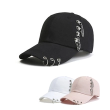 Detail of punk style baseball cap with silver metal rings and side chain decorations