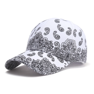 Close-up of white baseball cap with black paisley print and curved brim details