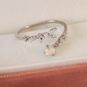 Macro shot of silver floral adjustable ring with opal and pavé cubic zirconia details