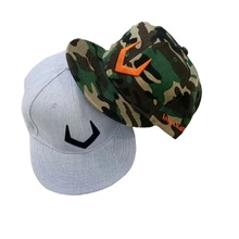 Detail view of 3D fish embroidery on gray and jungle camouflage flat brim baseball caps