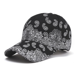 Close-up of black baseball cap featuring white paisley and bohemian patterns on crown