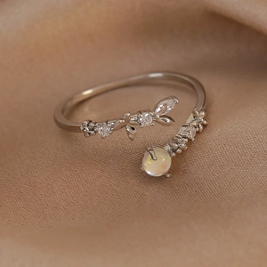 Macro shot of silver floral adjustable ring with zircon pave and white opal stone