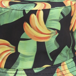 Black bucket hat featuring a vibrant tropical banana and green leaf print on canvas fabric