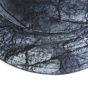 Macro shot of canvas bucket hat detail with blue tie-dye marble texture and brim stitching