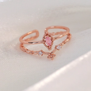 Macro shot of rose gold double-layer open ring with pink marquise zircon and flower detail