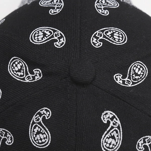 Close-up of black paisley pattern fabric and stitching on top of the baseball cap