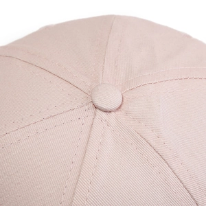 Close-up of pink baseball cap crown showing twill fabric texture and stitched button detail