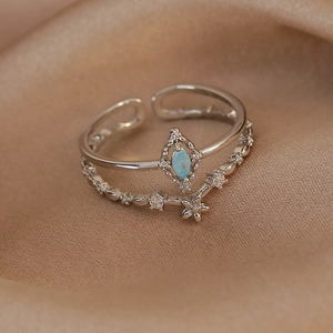 Detail of adjustable silver double-layer ring with blue marquise stone and zircon flower