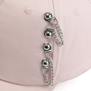 Pink cotton baseball cap featuring silver metal rings and hanging chains street style