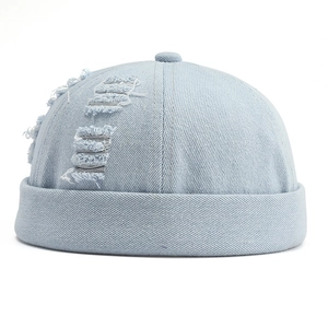 Détail du bonnet docker en denim bleu clair avec trous usés et bord roulé de style rétro