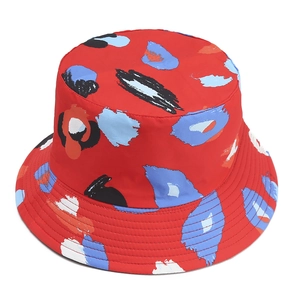 Detailed view of red cotton bucket hat featuring abstract colorful leopard print and stitching