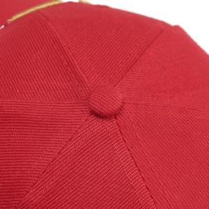 Detailed macro view of the red cotton baseball cap top button and twill stitching