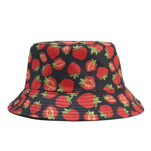 Detail view of cotton bucket hat featuring a vibrant red strawberry print on black fabric