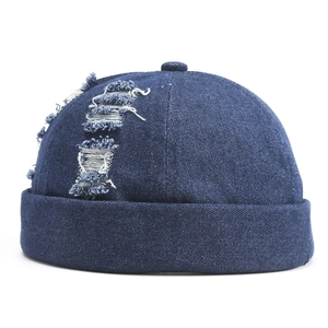 Détail du bonnet docker en jean bleu montrant une texture usée et des finitions vintage