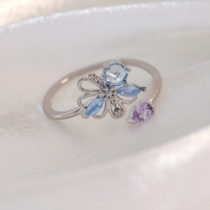 Macro detail of adjustable silver ring with light blue and purple marquise zircons