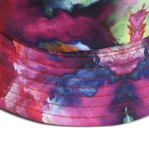 Tie-dye canvas bucket hat with vibrant star galaxy pattern and red stitch brim detail