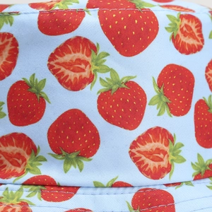 Close-up of light blue bucket hat with strawberry print and twill fabric texture