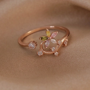 Detail of rose gold flower ring with colorful cubic zirconia on silk background