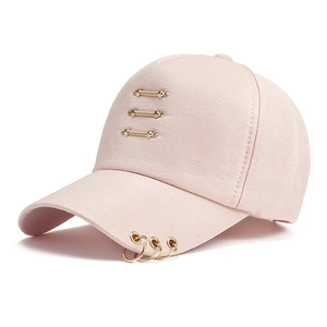 Close-up of pink cotton baseball cap with gold metal rings and decorative bars