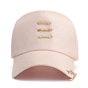 Close-up of light pink baseball cap featuring golden metal rings and vertical bars detail