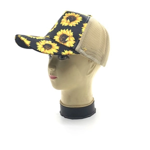 Detail view of sunflower print visor and breathable mesh back on the trucker hat