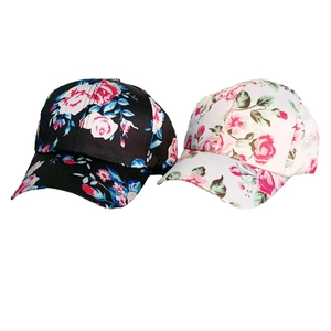 Detail of floral baseball caps with pink rose print on black and white twill fabric