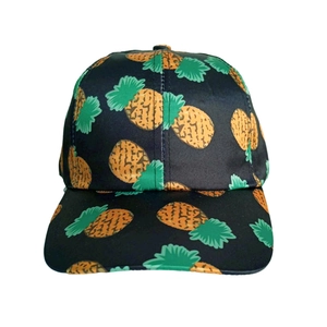 Close-up of black baseball cap featuring vibrant yellow pineapple print and tropical style