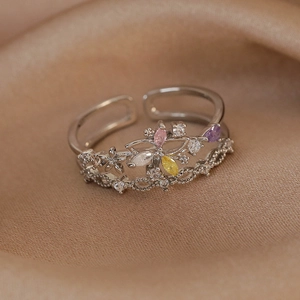 Detailed macro of adjustable silver ring with colorful marquise zircons and floral weaving