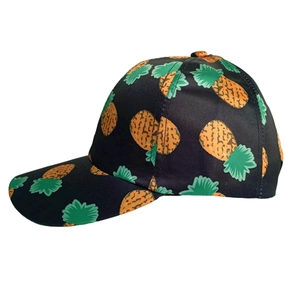 Detail of black baseball cap with vibrant yellow pineapple print and curved brim