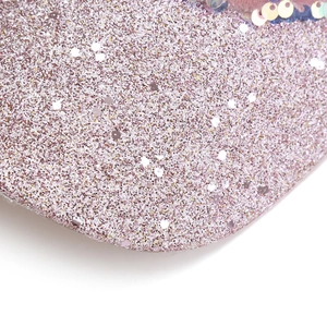 Macro detail of sparkly pink sequins and glitter texture on the stylish baseball cap brim