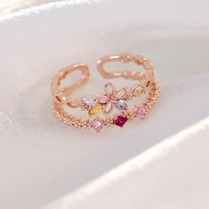 Macro view of adjustable rose gold ring with multi-color zircon stones on white silk